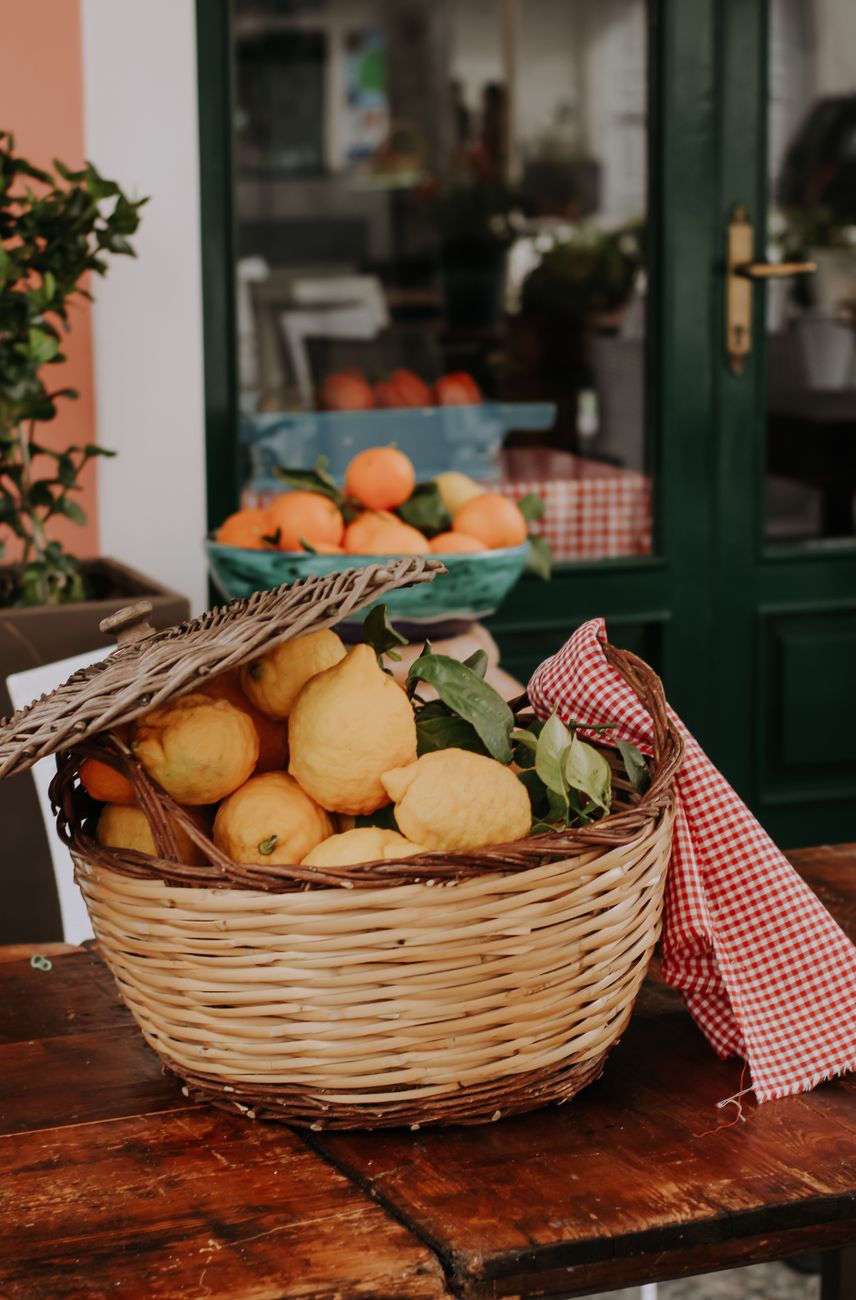 Harvested ripe citrus lemons in rustic wooden crate overlooking the ocean